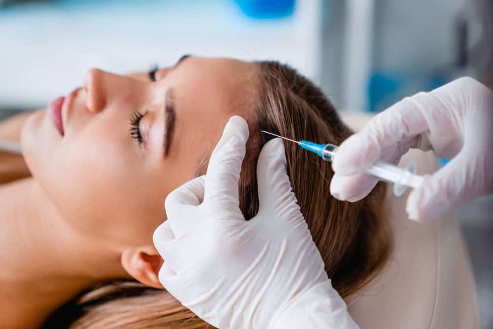 Woman undergoing a hair restoration treatment.