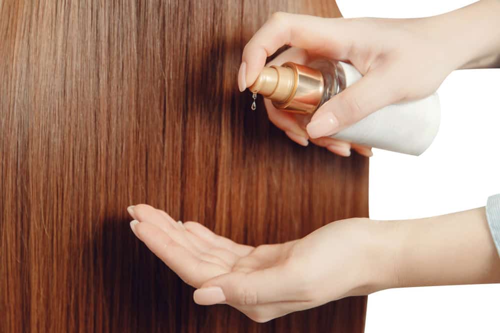 Applying rosemary oil for hair growth by dispensing drops onto the palm before scalp use