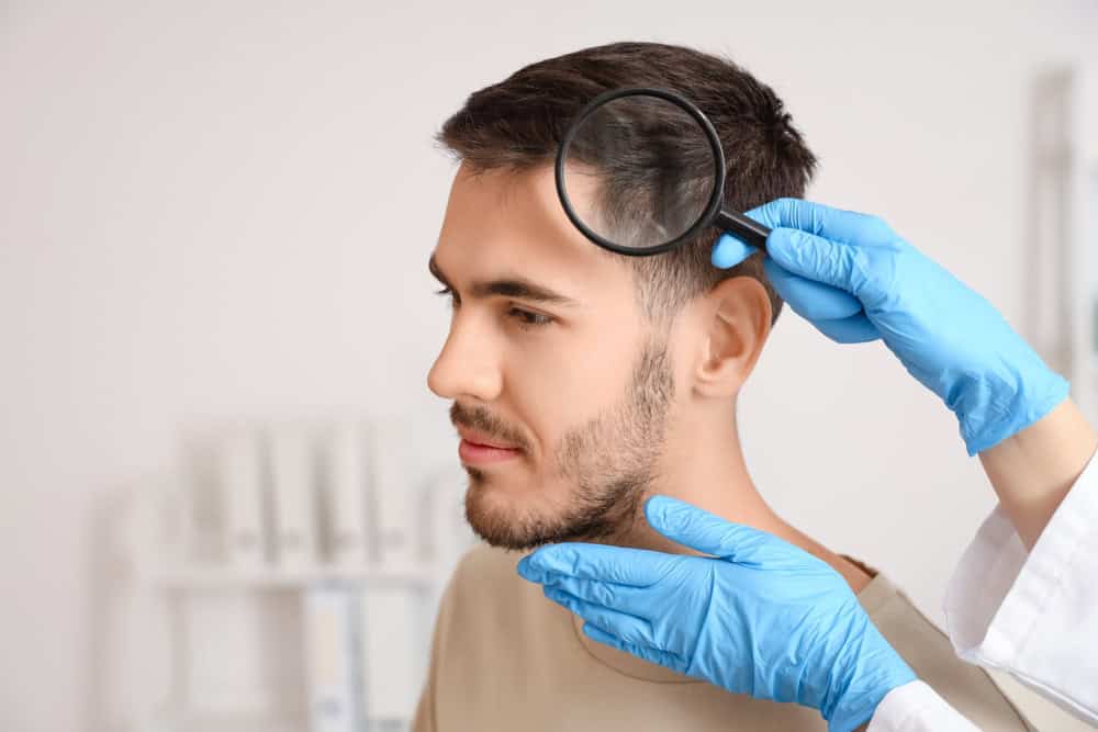 A physician examining a patient’s scalp under bright light to evaluate telogen effluvium symptoms.