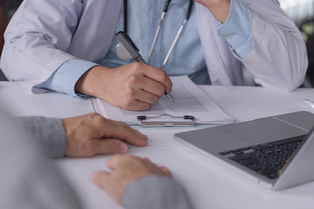 A doctor and patient reviewing a treatment plan for one of the recurring types of keloid scars