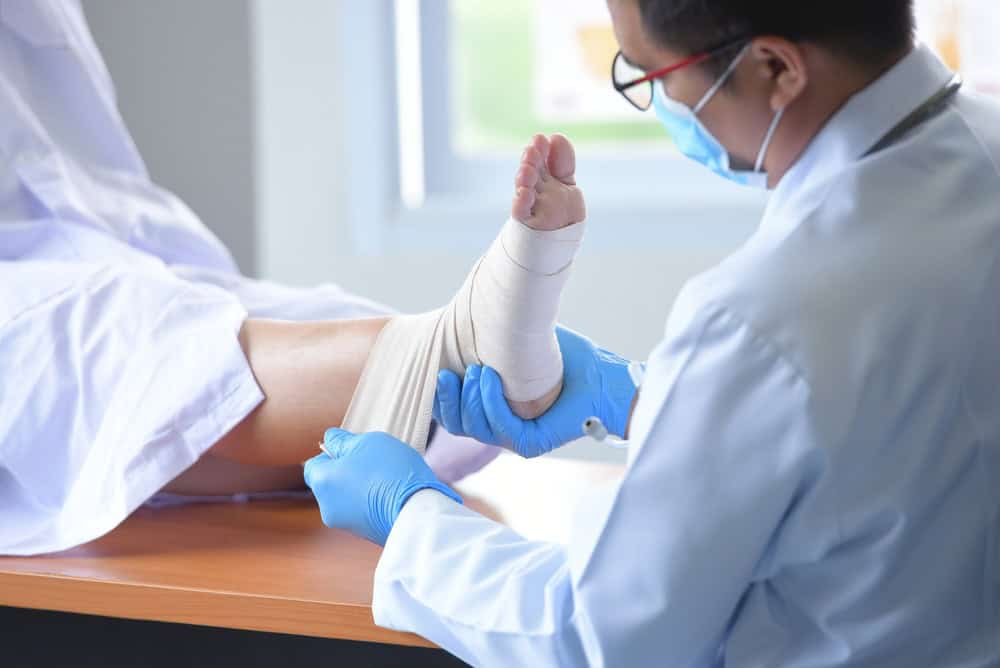A specialist applying advanced dressing and regenerative wound care to a diabetic foot ulcer.