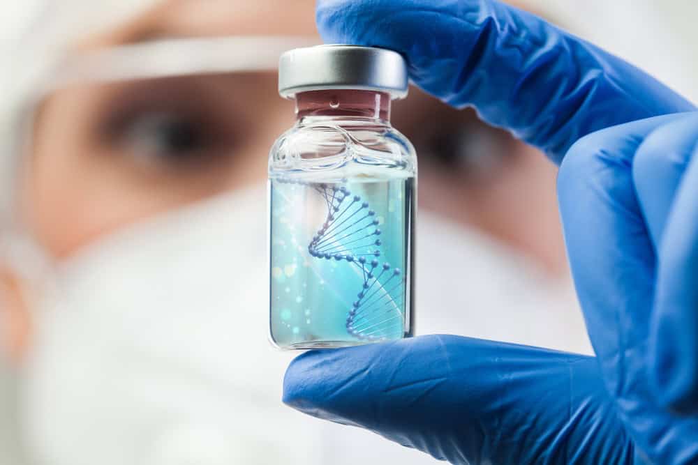 A lab worker holding a vial of mesenchymal stromal cells with a CD90 marker.